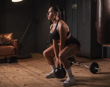 Caucasian woman doing squats with kettlebell in retro gym