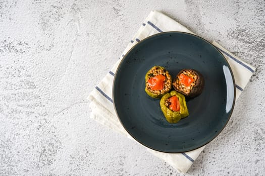 Stuffed green bell pepper and eggplant with olive oil on stone table