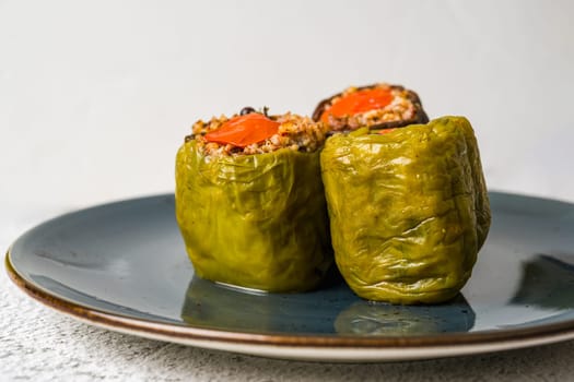 Stuffed green bell pepper and eggplant with olive oil on stone table