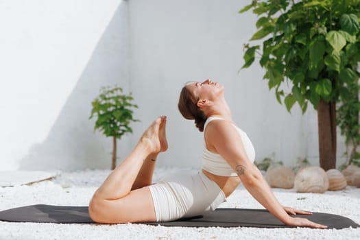 yoga stretching outdoors. side view of overweight woman practicing yoga on white background, body care concept, fighting excess weight losing weight