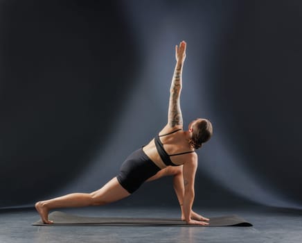 girl doing yoga and stretching, yoga and stretching poses on a dark background, yoga practice. fighting excess weight losing weight