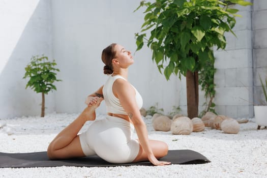 yoga stretching outdoors. side view of overweight woman practicing yoga on white background, body care concept, fighting excess weight losing weight