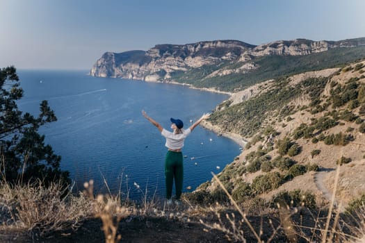 Happy woman standing with her back in nature in summer with open hands posing with mountains. Woman in the mountains, eco friendly, summer landscape active rest.