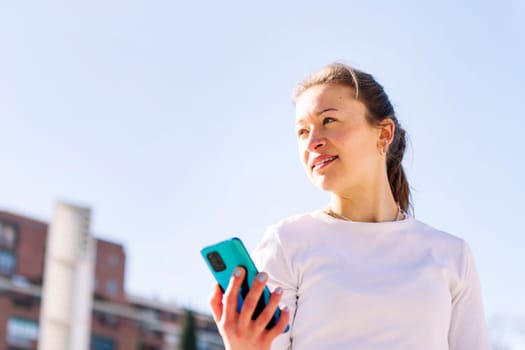 young caucasian woman using mobile phone, concept of technology of communication and social media, copy space for text