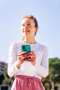 smiling caucasian woman using mobile phone, concept of technology of communication and social media