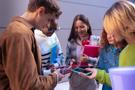 Group of friends using looking at their smartphones Multiracial teenagers browsing the internet with mobile phone on campus