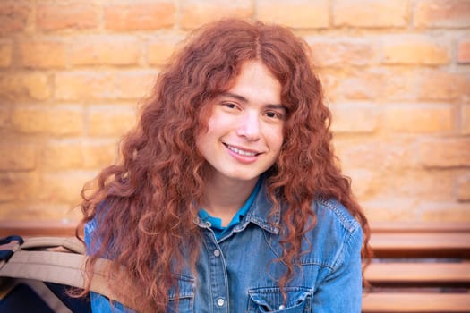 Attractive confident Caucasian teenage student looking at camera outdoors. Boy standing with happy face.