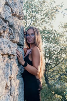 Woman travel sea. Young Happy woman in a long red dress posing on a beach near the sea on background of volcanic rocks, like in Iceland, sharing travel adventure journey