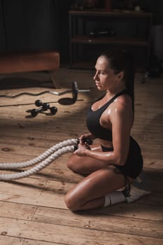 Caucasian woman posing with ropes in retro gym