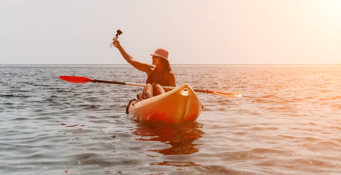 Happy smiling woman in kayak on ocean, paddling with wooden oar. Calm sea water and horizon in background