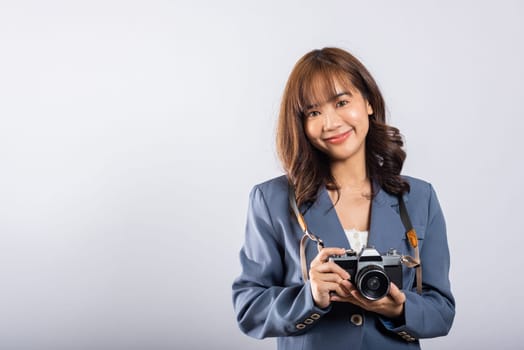 Attractive energetic happy Asian portrait beautiful cute business young woman teen excited smiling holding vintage photo camera, studio shot isolated on white background, traveler female photographer