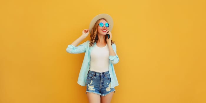 Happy cheerful young woman laughs calling on phone, girl talking on the smartphone in summer tourist straw hat looks away on yellow background