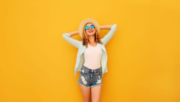 Summer vacation, fashion, lifestyle. Happy joyful relaxed young woman enjoying sunny warm day in tourist straw hat, glasses standing on bright yellow background