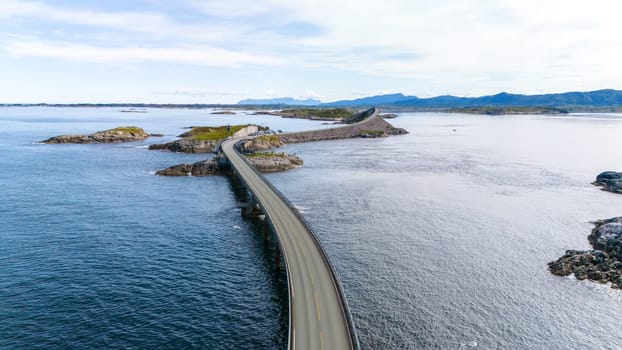 An aerial view of the Atlantic Road in Norway, showcasing a winding bridge connecting islands and stretching across the stunning blue waters of the North Sea.