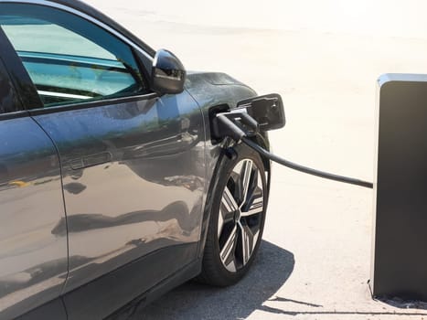 An electric car charging at the Electric vehicle charging station in the parking lot