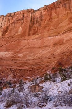 Breathtaking view of a snow-dusted landscape in Capitol Reef National Park's Grand Wash, Utah. Majestic red sandstone cliffs under a clear blue sky create a serene and picturesque winter scene - USA