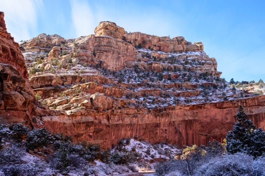 Captivating view of snow-covered rocky cliffs in the Grand Wash, Capitol Reef National Park, Utah. The blue sky enhances the stunning landscape, highlighting the beauty of the rock formations - USA