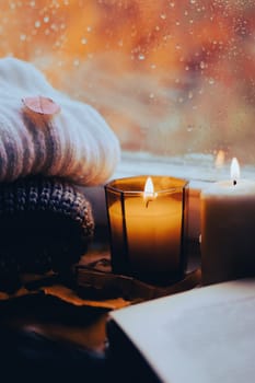 A burning candle on the window is autumn . the comfort of home . autumn comfort . autumn mood. The chondra .
