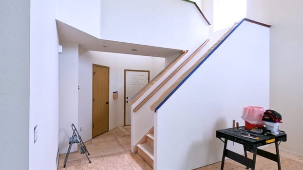 Broomfield, Colorado, USA-June 11, 2024-Slow motion-A staircase in a home undergoing renovation, featuring protective coverings and masking tape to safeguard surfaces. The area is prepared for painting or further construction work, highlighting a common home improvement project.