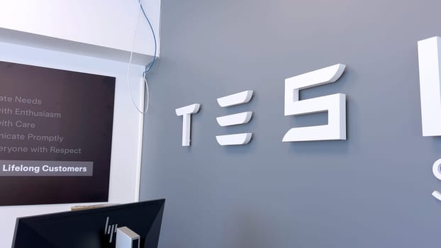 Colorado Springs, Colorado, USA-June 12, 2024-Slow motion-Image of the Tesla Service Center sign on a gray wall, indicating the location for Tesla vehicle maintenance and repairs. The sleek and modern design reflects the company innovative branding.