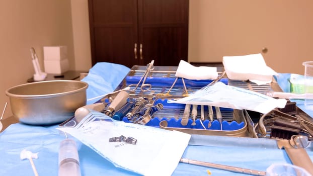 Denver, Colorado, USA-June 10, 2024-Slow motion-A table set with various sterilized surgical instruments, ready for a medical implant procedure. The organized setup includes forceps, scalpels, gauze, and syringes, emphasizing the precision and cleanliness required for implant surgery.