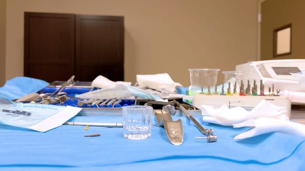 Denver, Colorado, USA-June 10, 2024-Slow motion-A table set with various sterilized surgical instruments, ready for a medical implant procedure. The organized setup includes forceps, scalpels, gauze, and syringes, emphasizing the precision and cleanliness required for implant surgery.