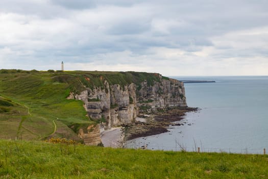 the chalk cliffs of le treport in France in Normandy with a blue sky with white clouds and the sea