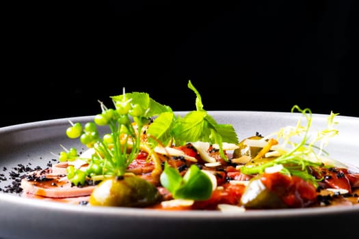 Beef tongue with sauce and vegetables on white plate