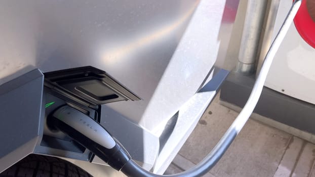 Pueblo, Colorado, USA-June 10, 2024-Slow motion-A Tesla Cybertruck is parked and charging at a Tesla Supercharger station in an underground parking garage. The futuristic design of the Cybertruck stands out against the industrial background.