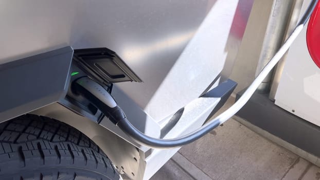 Pueblo, Colorado, USA-June 10, 2024-Slow motion-A Tesla Cybertruck is parked and charging at a Tesla Supercharger station in an underground parking garage. The futuristic design of the Cybertruck stands out against the industrial background.