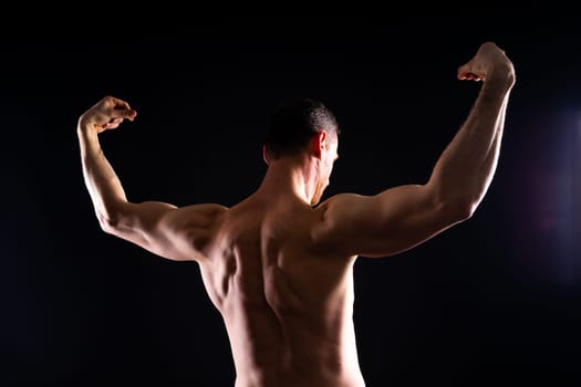 Fitness, man and back of body builder in closeup with strong muscle from training and workout. Health, male person or topless athlete in studio for exercise and weight loss with black background