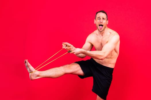 Full length portrait of a young man exercising with a skipping rope and looking at camera