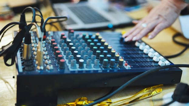 A skilled sound engineer uses a tablet to fine-tune the audio levels during a dynamic live concert performance.