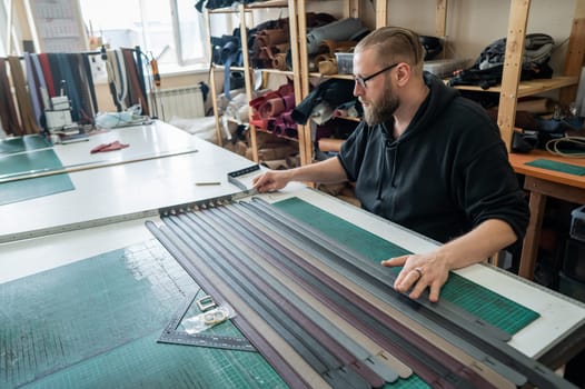 Leatherworker making leather belts in workshop