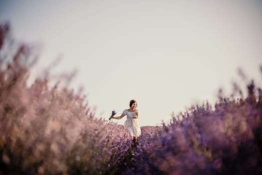 Lavender field happy girl in white dress with a scythe runs through a lilac field of lavender. Aromatherapy travel.