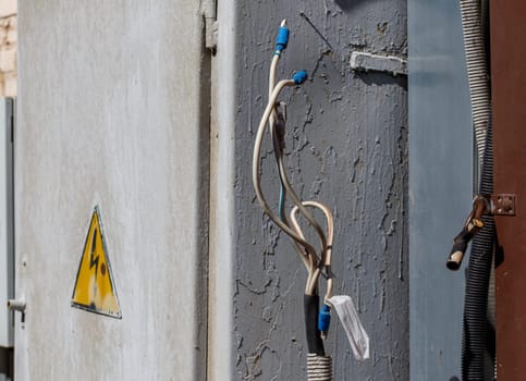 bare wire lugs in front of outdoors electrical box at sunny day, closeup with selective focus