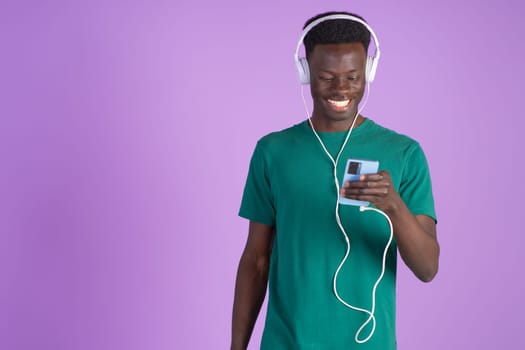 A man standing wearing headphones and a green shirt.