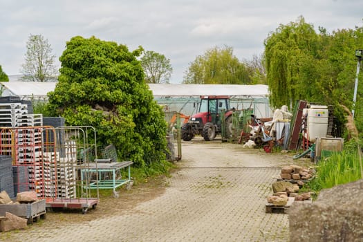 A neglected dirt road littered with various junk items on both sides, creating a cluttered and unkempt environment.