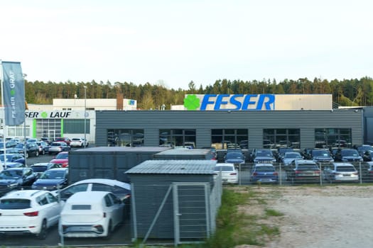 Bayreuth, Germany - April 30, 2023: The FESER car dealership building seen in the evening with a display of vehicles parked in front.