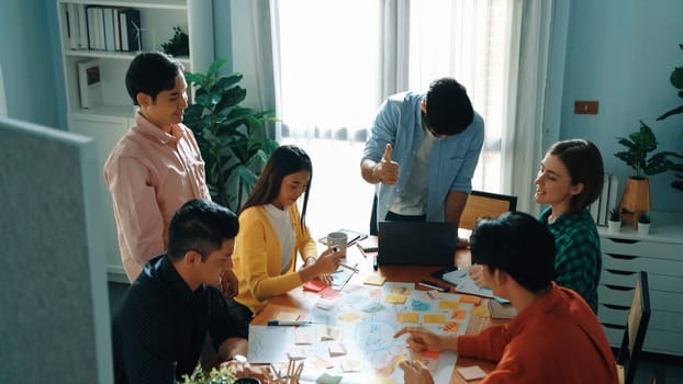 Top view of diverse business people drawing mind map by using marker while brainstorm idea and writing on sticky notes. Group of smart team sharing idea while planning creative strategy. Convocation.