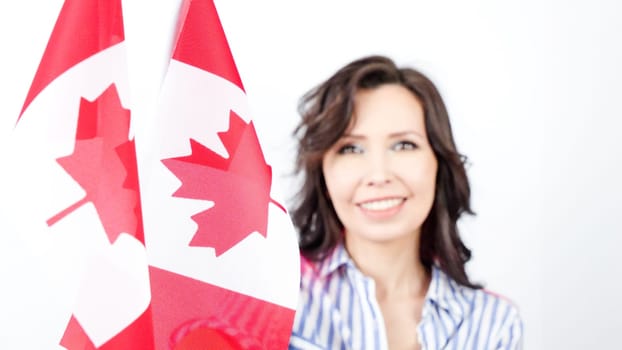 Happy woman is holding two Canadian flags. National pride. Election. Patriot