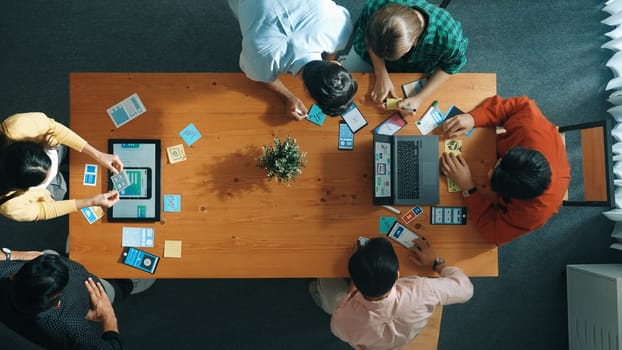 Programmer team brainstorm and plan Ux Ui design for mobile phone while present idea by using laptop at meeting. Software developer look at wireframe prototype while write at sticky note.Convocation.