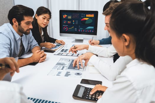 Diverse corporate audit team or company bookkeeper and accountant consultant calculate account expenses and income budget for tax refunds using calculators in busy workspace. Prudent