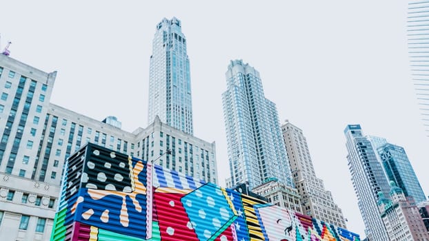 Colorful abstract pattern on tall city building wall. Bright, eye-catching colors, complex, interesting design. Low angle view enhances building height. Art transforms urban space.