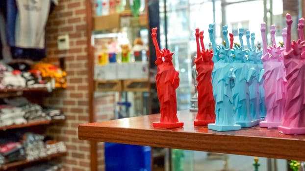 A wide variety of New York City souvenirs, including figurines of King Kong, the Statue of Liberty, and the Empire State Building, are displayed for sale on shelves in a store.