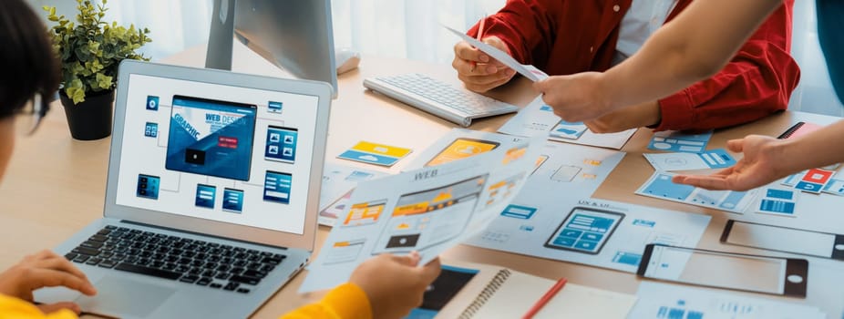 Panorama banner of startup UX developer or company employee design user interface or UI prototype for mobile application or website software with software display on laptop monitor in office. Synergic
