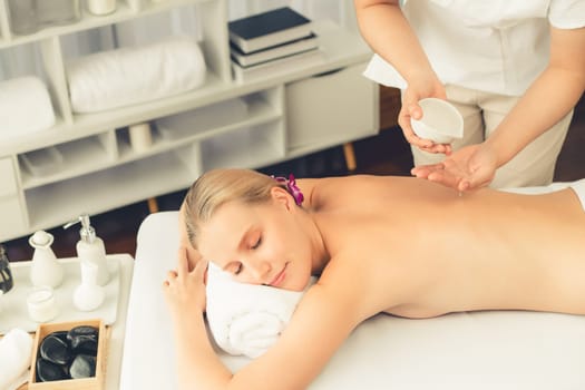 Masseur hands pouring aroma oil on woman back. Masseuse prepare oil massage procedure for customer at spa salon in luxury resort. Aroma oil body massage therapy concept. Quiescent