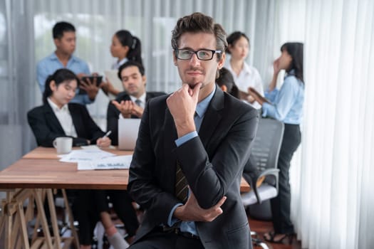 Portrait of happy businessman looking at camera with motion blur background of business people movement in dynamic business meeting. Habiliment