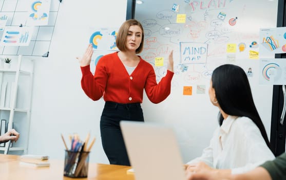 Professional attractive female leader presents creative marketing plan by using brainstorming mind mapping statistic graph and colorful sticky note at modern business meeting room. Immaculate.