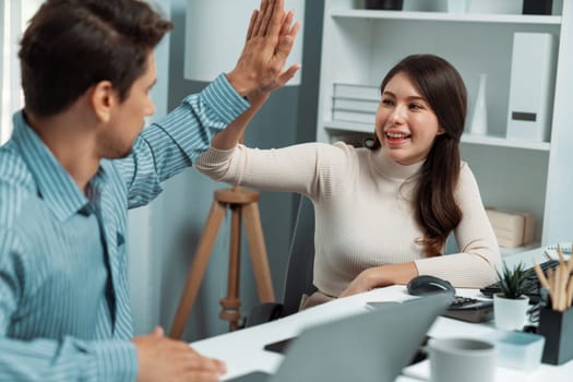 Smiling happy coworkers making hand high five also raising fist up of successful creative business project plan with highest profit value job in casual day at modern office at morning time. Postulate.